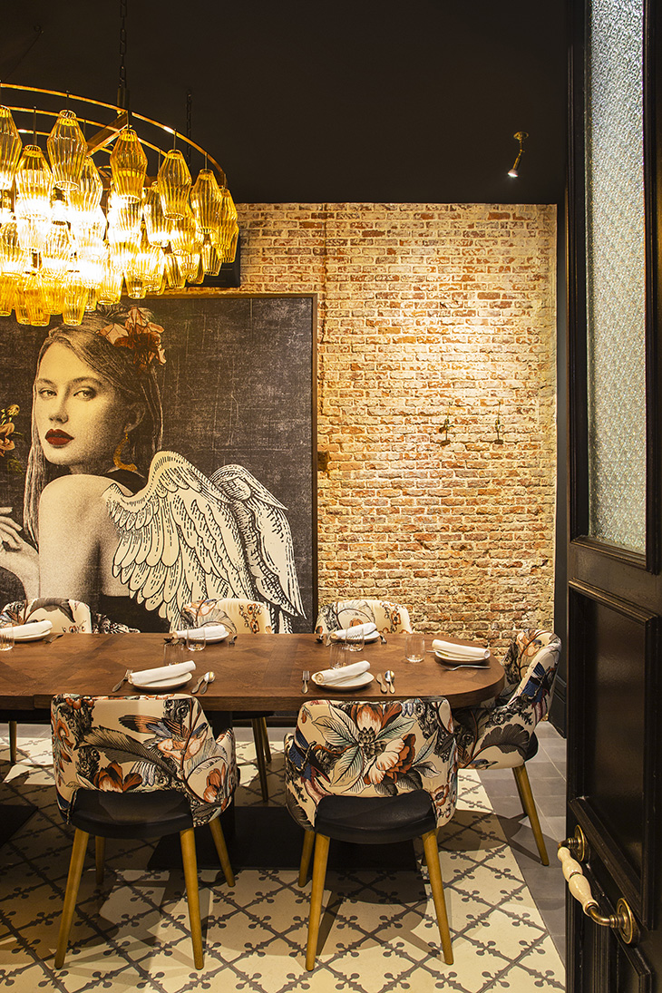 Interiorismo de restaurante por Pablo Peyra Studio. Sala comedor pared con collage ángel.
