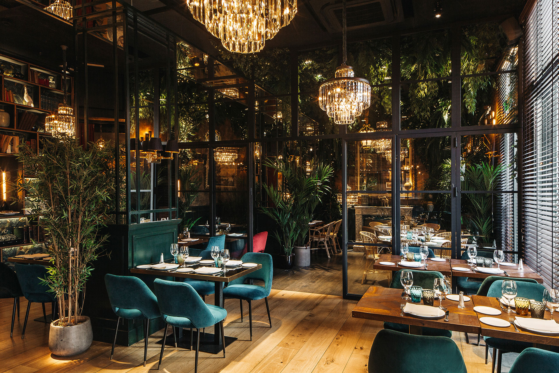 Diseño de restaurante por Pablo Peyra Studio. Proyecto Feroz. Vista de dos espacios comedor separados por galería de hierro y cristal.