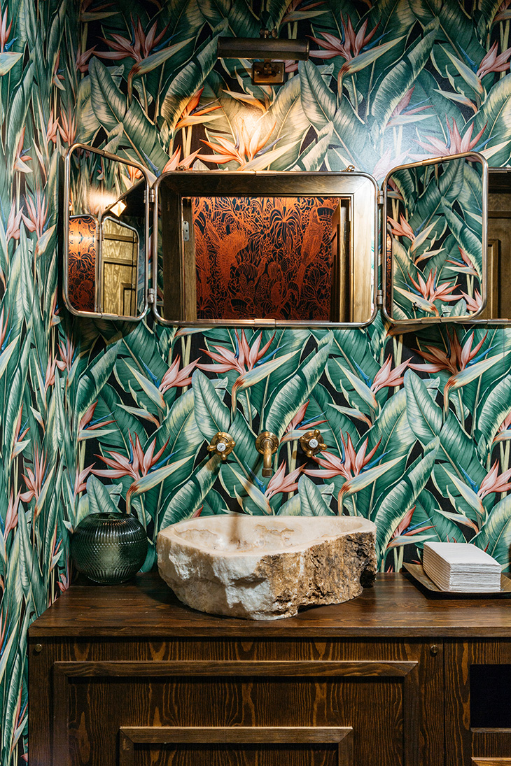 Interiorismo de restaurante por Pablo Peyra Studio. Proyecto Restaurante Feroz, Barcelona. Detalle del tocador de los aseos para caballeros con papel pintado estilo jungla, lavamanos de piedra y mueble en madera colonial. Interiorismo de restaurante por Pablo Peyra Studio. Proyecto Restaurante Feroz, Barcelona. Detalle del tocador de los aseos para caballeros con papel pintado estilo jungla, lavamanos de piedra y mueble en madera colonial.