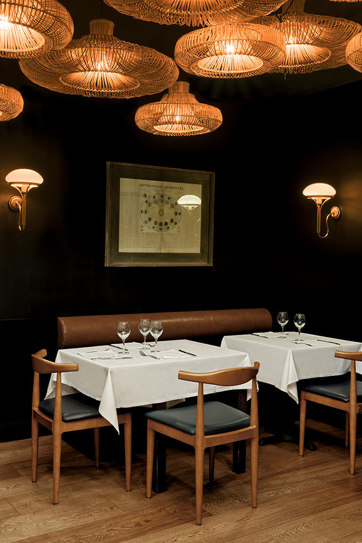 Diseño interior del restaurante Les 15 nits por Pablo Peyra Studio. Comedor con lámparas de fibras naturales en el techo.