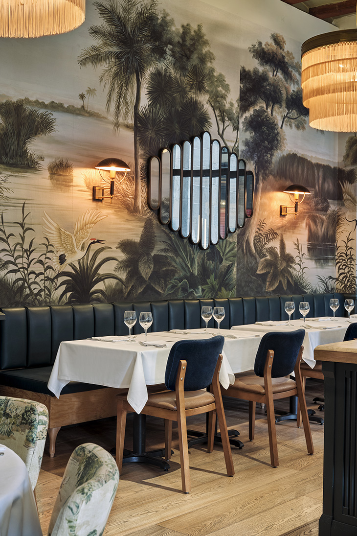 Diseño interior del restaurante Les 15 nits por Pablo Peyra Studio. Vista comedor con paredes empapeladas con motivo oasis.