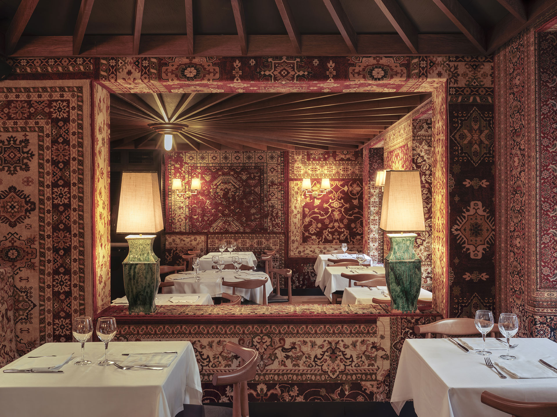 Diseño del restaurante Les 15 nits por Pablo Peyra Studio. Vista comedor estilo árabe con paredes tapizadas con alfombras persas..