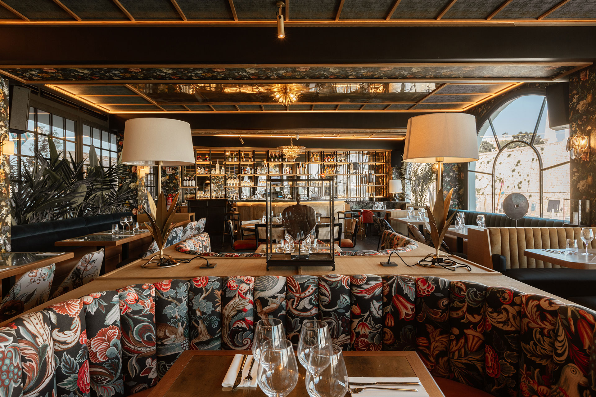 Diseño de restaurante por Pablo Peyra Studio. Proyecto Restaurante Ciutadella, Menorca. Vista general del comedor con 2 lámparas con pie de hojas de latón.