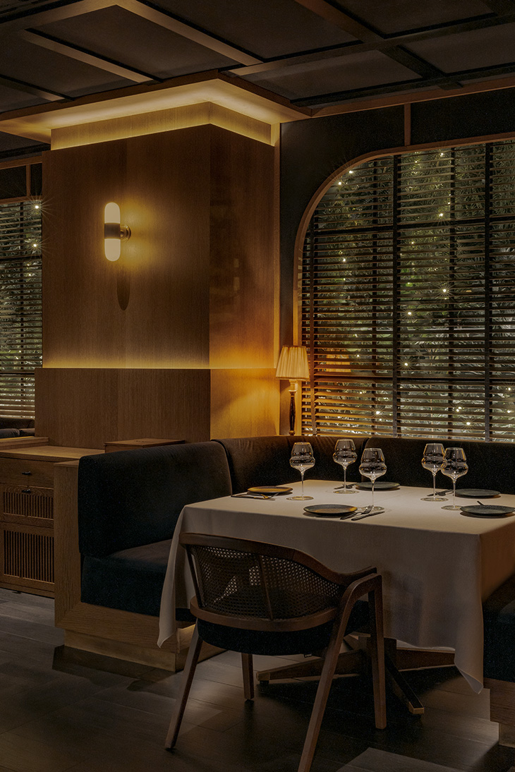 Interiorismo restaurante Noble por Pablo Peyra Studio. Detalle de mesa con banco esquinero con iluminación envolvente en Noble.