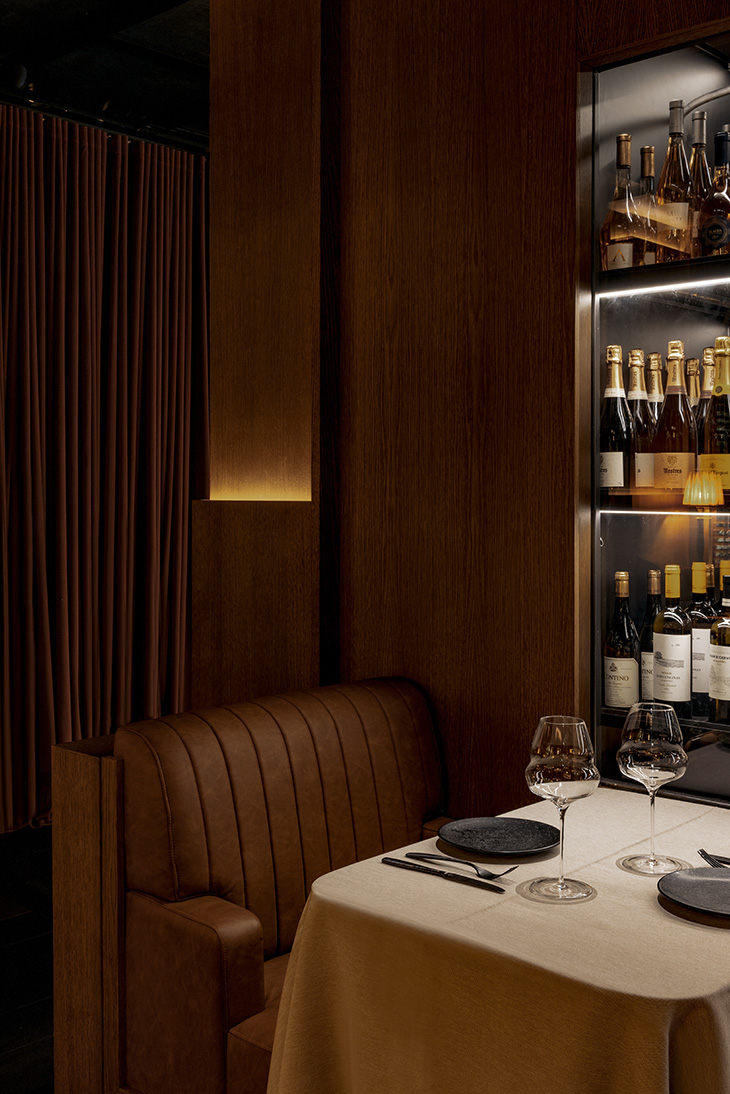 Detalle de mesa para dos personas con cava de vinos en la pared e iluminación cálida. Interiorismo de Pablo Peyra. Detalle de mesa para dos personas con cava de vinos en la pared e iluminación cálida. Interiorismo de Pablo Peyra.
