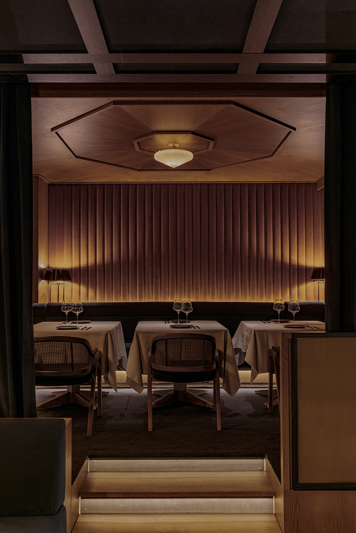 VIsta de comedor en altillo con pared tapizada y techo de madera, mesas para dos comensales y butacas de bambú. Pablo Peyra Interiorismo. VIsta de comedor en altillo con pared tapizada y techo de madera, mesas para dos comensales y butacas de bambú. Pablo Peyra Interiorismo.